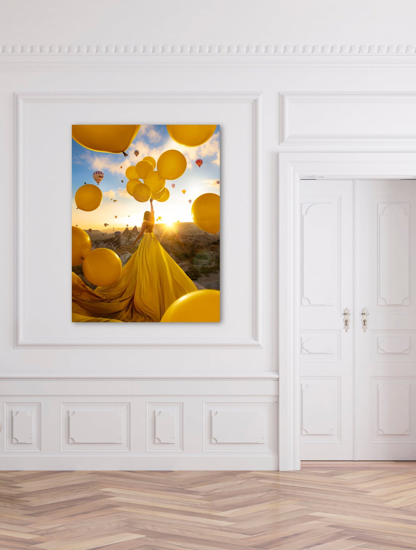 Tableau photographie d'art accroché dans un appartement chic montrant une femme en robe jaune et des ballons jaunes